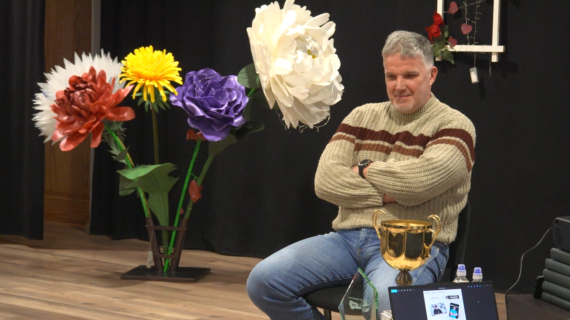 Sandis Prūsis tikšanās laikā Blāzmas bibliotēkā pie trofejas kausa.