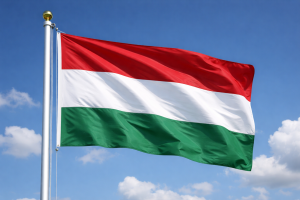Ungārijas valsts karogs plīvo mastā uz zilām debesīm.