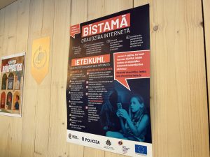 Plakāts bibliotēkā ar ieteikumiem par drošu draudzību internetā un rīcību bīstamās situācijās tiešsaistē.