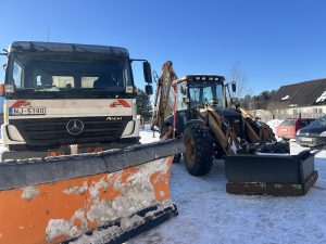 Pašvaldības sniega tīrīšanas tehnika – kravas auto ar sniega lāpstu un traktors ziemas apstākļos.