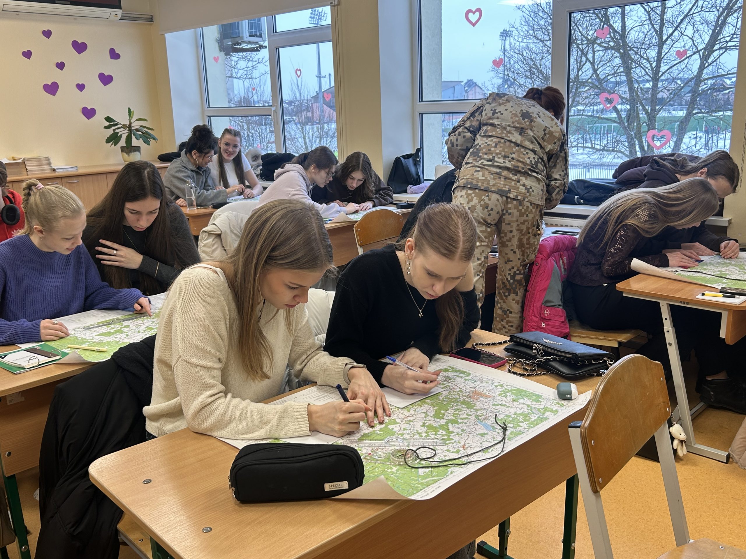 Skolēni klasē strādā ar kartēm, veicot uzdevumus ģeogrāfijas stundā.