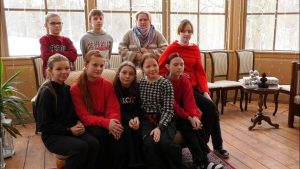 Skolēnu grupa ar pedagogu pulcējas kopīgai nodarbībai izglītības iestādē