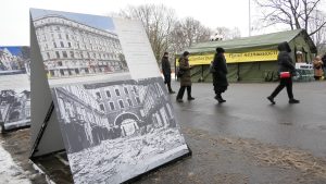 Izstādes stends ar kara postījumu fotogrāfijām Rīgā un “Nesalaužamības punkta” telts fonā