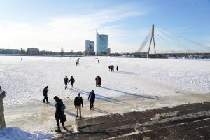 Cilvēki pastaigājas pa aizsalušo Daugavu Rīgā pie Vanšu tilta