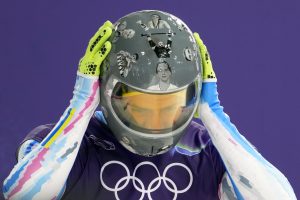 Ukrainas skeletonists Vladislavs Heraskevičs treniņā pielabo ķiveri pirms brauciena.