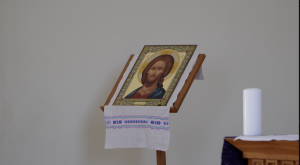 Ikona ar Jēzus Kristus attēlu baznīcas telpā gavēņa laikā, blakus novietota balta svece.