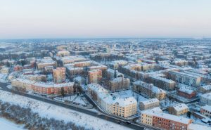 Daugavpils Centra apkaime ziemā – skats no augšas ar sniegotām ielām un daudzstāvu dzīvojamām ēkām.