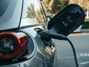 Elektromobilis tiek uzlādēts pie publiskās uzlādes stacijas.