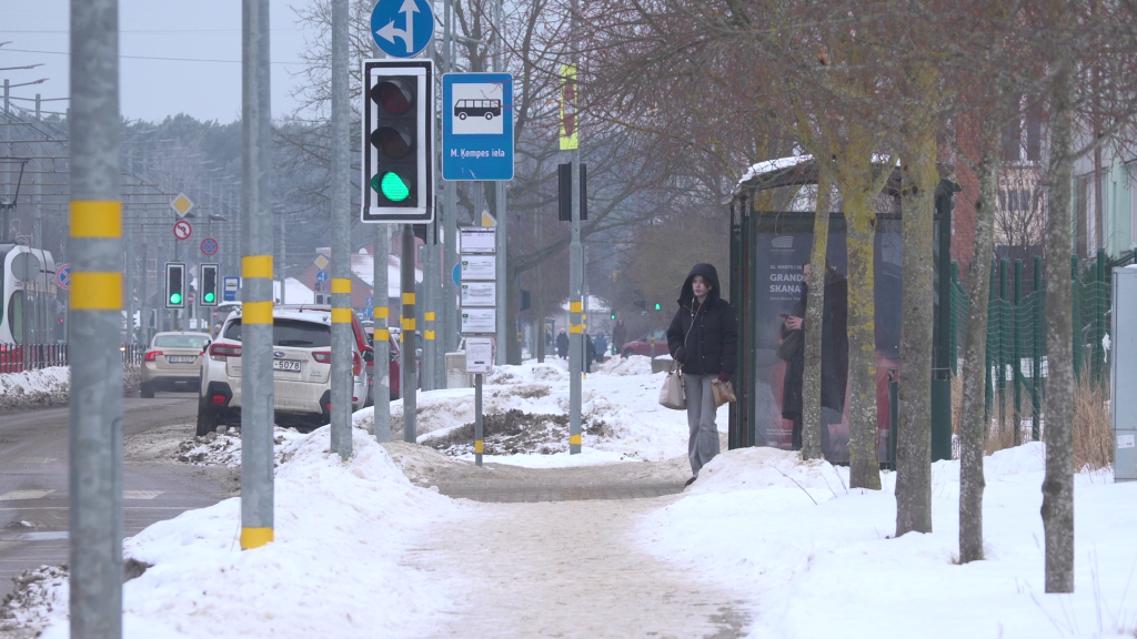 Gājēju ietve ar sniegu un autobusa pietura Liepājā ziemas laikā