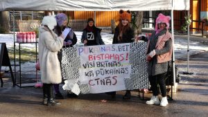 Aktivisti ar plakātu par pūkainajiem dzīvniekiem pasākumā pie Rīgas Zooloģiskā dārza
