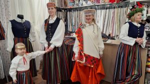 Sievietes un bērns Ogrē tautastērpu darbnīcā demonstrē Ziemeļkurzemes brunčus no tradicionālā un pārstrādātas vilnas auduma.