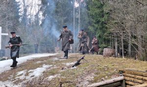 Vēsturiskās kaujas rekonstrukcija mežā ar karavīriem Otrā pasaules kara formās.