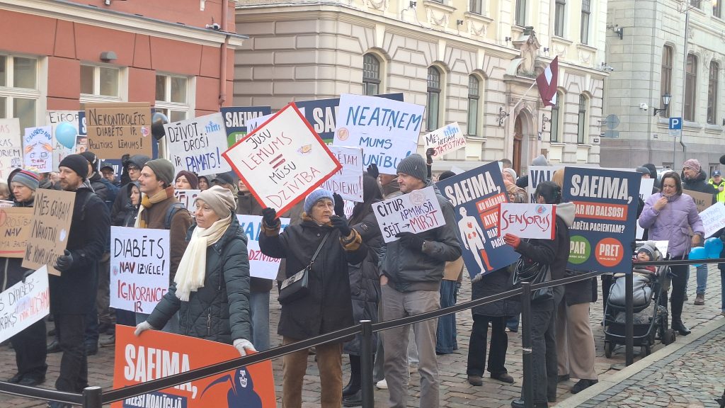 Protestētāji ar plakātiem pie Saeimas Rīgā