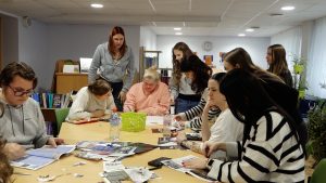 Jaunieši grupā strādā pie radoša uzdevuma bibliotēkā
