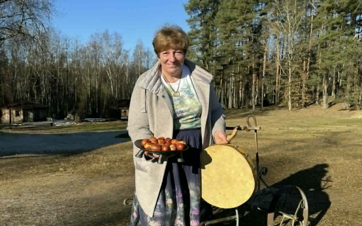 Aelita Vilde-Batņa dabā tur rokās šķīvi ar pirts rituāla elementiem.