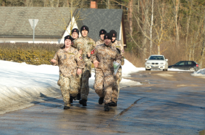 Jaunsargi militārajā formā skrien treniņa laikā pa ceļu