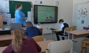 Skolotāja vada stundu klasē, skolēni pilda uzdevumus