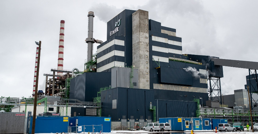 Auveres elektrostacija Igaunijā ar augstiem skursteņiem un industriālām ēkām mākoņainā laikā.
