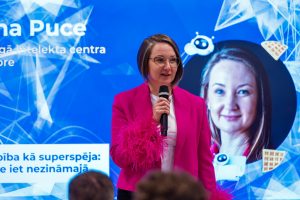 Guna Puce uzstājas ar mikrofonu konferencē par mākslīgo intelektu