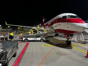 airBaltic lidmašīna lidostā nakts laikā pie bagāžas iekraušanas
