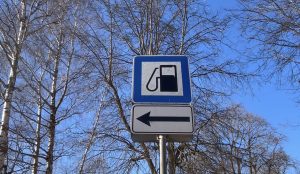 Ceļa zīme, kas norāda uz degvielas uzpildes staciju pa kreisi