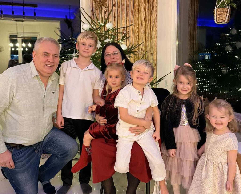 Sieviete ar ģimeni un bērniem pie Ziemassvētku eglītes