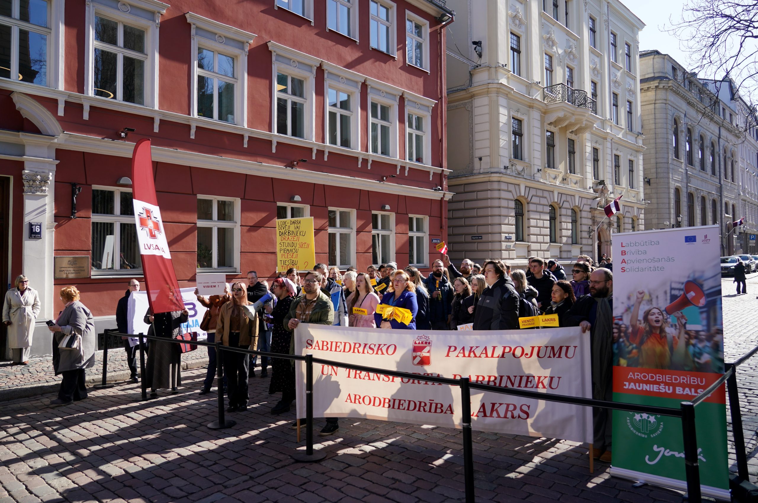 Protests pie Saeimas ar arodbiedrību plakātiem pret Darba likuma grozījumiem.