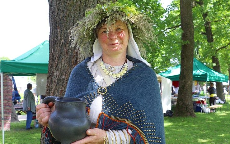 Līga Kondrāte tradicionālā tērpā ar māla trauku