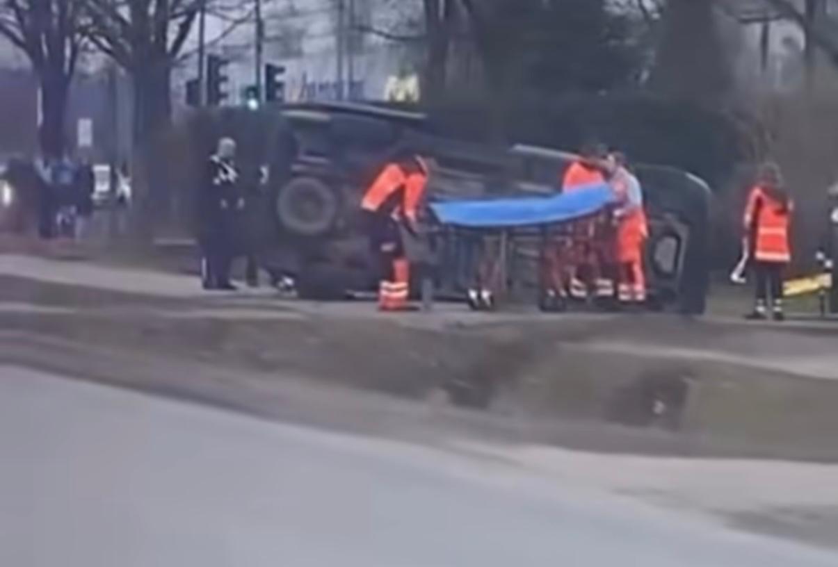 Glābēji sniedz palīdzību pēc auto avārijas, kur apgāzies transportlīdzeklis.