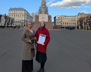 Divas sievietes pie Brīvības pieminekļa Rīgā ar apbalvojumu un diplomu