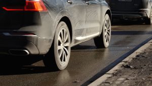 Automašīnas brauc pa slapju ceļu ziemas apstākļos.