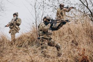 Karavīri militāro mācību laikā ar ieročiem laukā