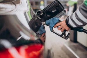 Automašīnas uzpilde degvielas uzpildes stacijā ar dīzeļdegvielas pistoli.