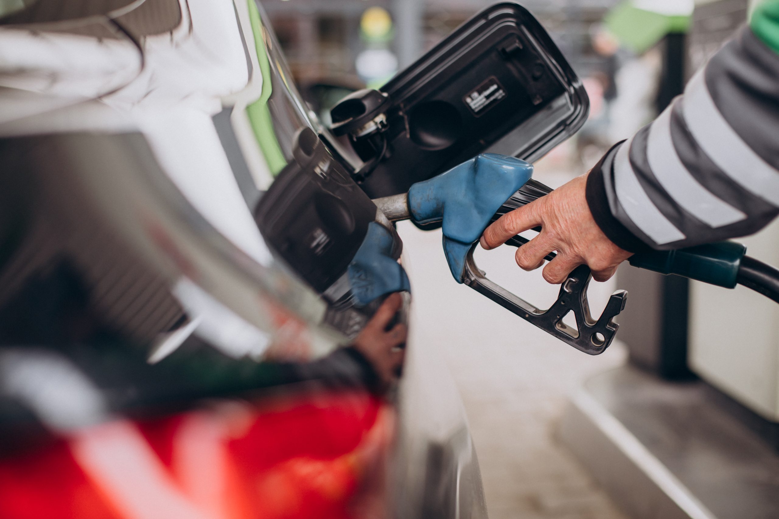 Automašīnas uzpilde degvielas uzpildes stacijā ar dīzeļdegvielas pistoli.