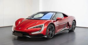 Sarkans sporta automobilis izstādīts salonā.