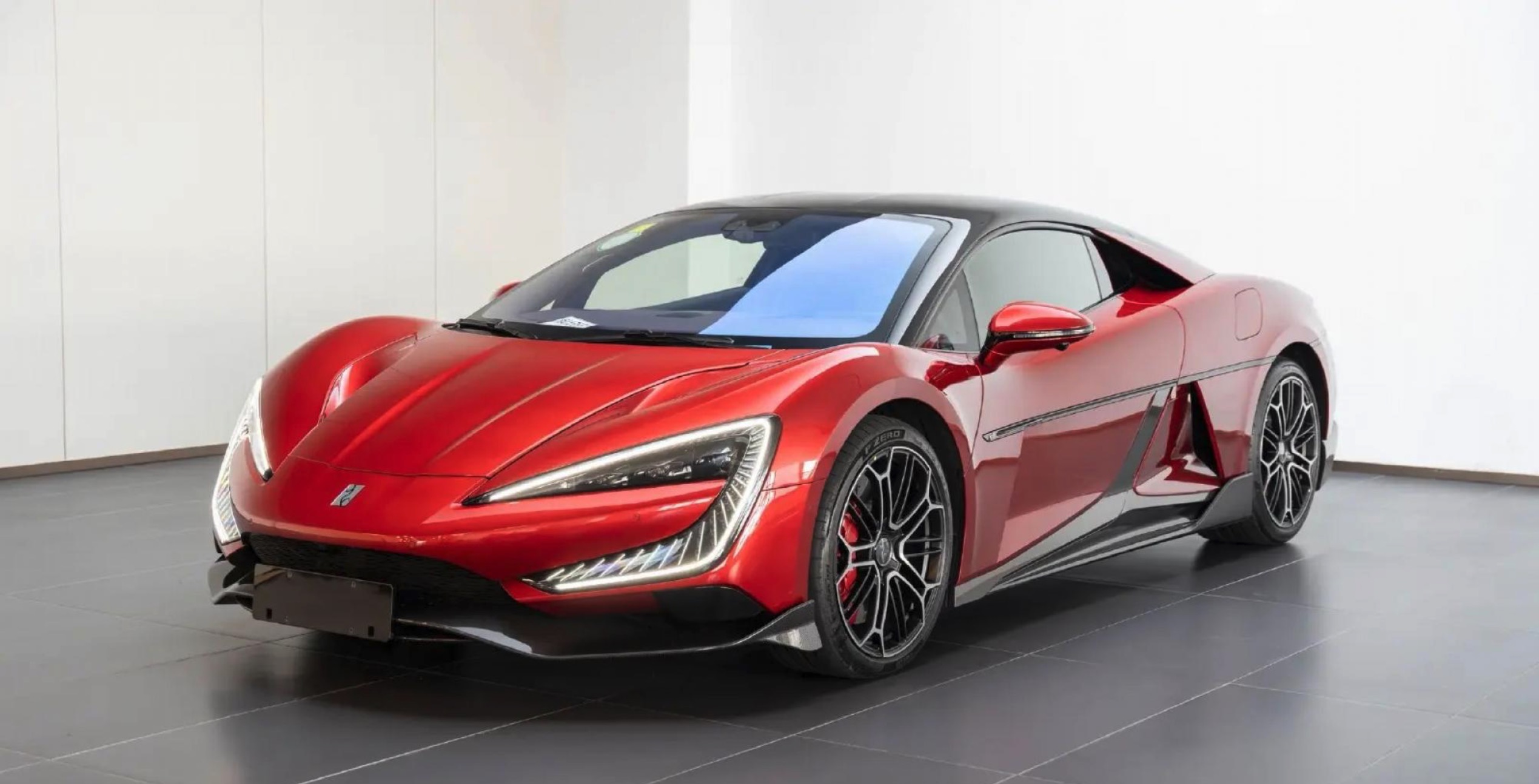 Sarkans sporta automobilis izstādīts salonā.