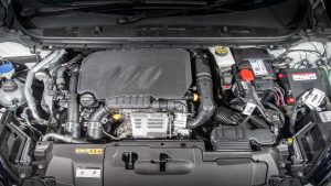 Automobiļa dzinēja nodalījums ar redzamu motoru un akumulatoru