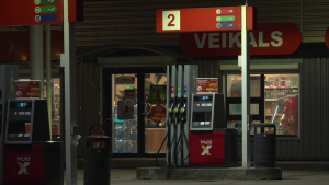 Degvielas uzpildes stacijas “95 miles” sūknis pie veikala ēkas vakara laikā.