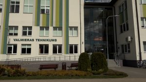 Valmieras tehnikuma ēkas ārskats ar krāsainu fasādi un stiklotu ieeju.