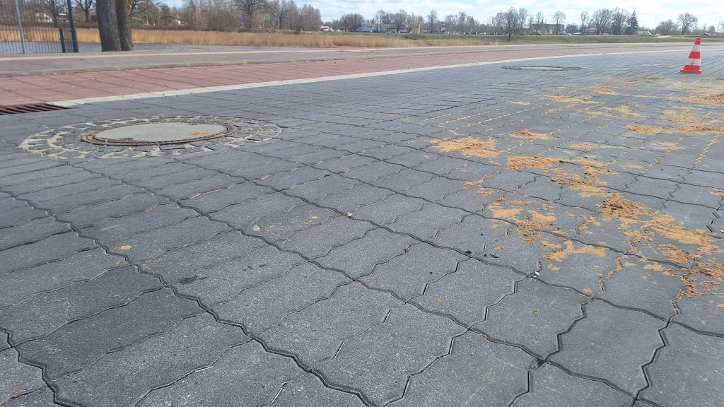 Bojāts bruģa segums ar smilšu izskalojumiem