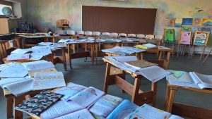 Valdorfa skolas klase ar skolēnu darbiem un mācību materiāliem uz galdiem.