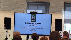 Auditorija klausās militāru prezentāciju par komunikāciju kara situācijā