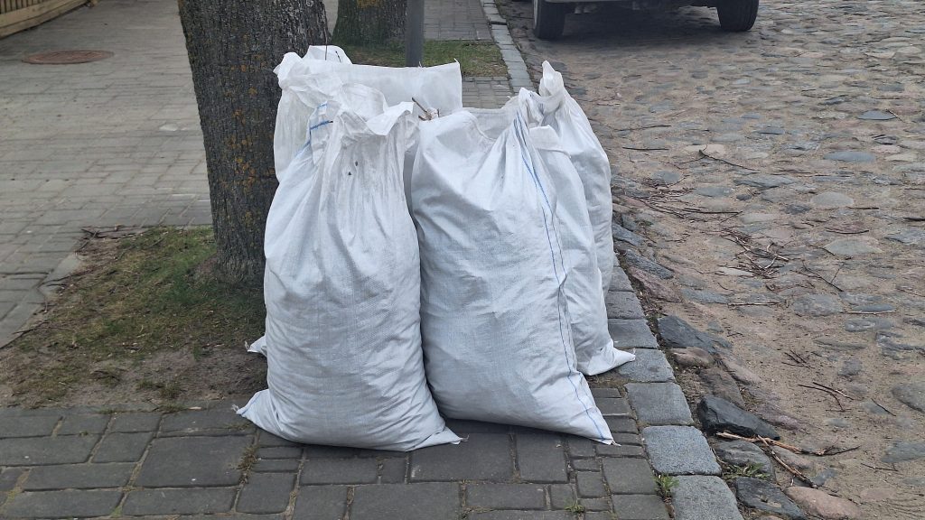 Baltos maisos savākti atkritumi novietoti pie ietves