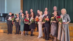 Čornobiļas avārijas seku likvidētāju godināšanas pasākuma dalībnieki ar ziediem un apbalvojumiem