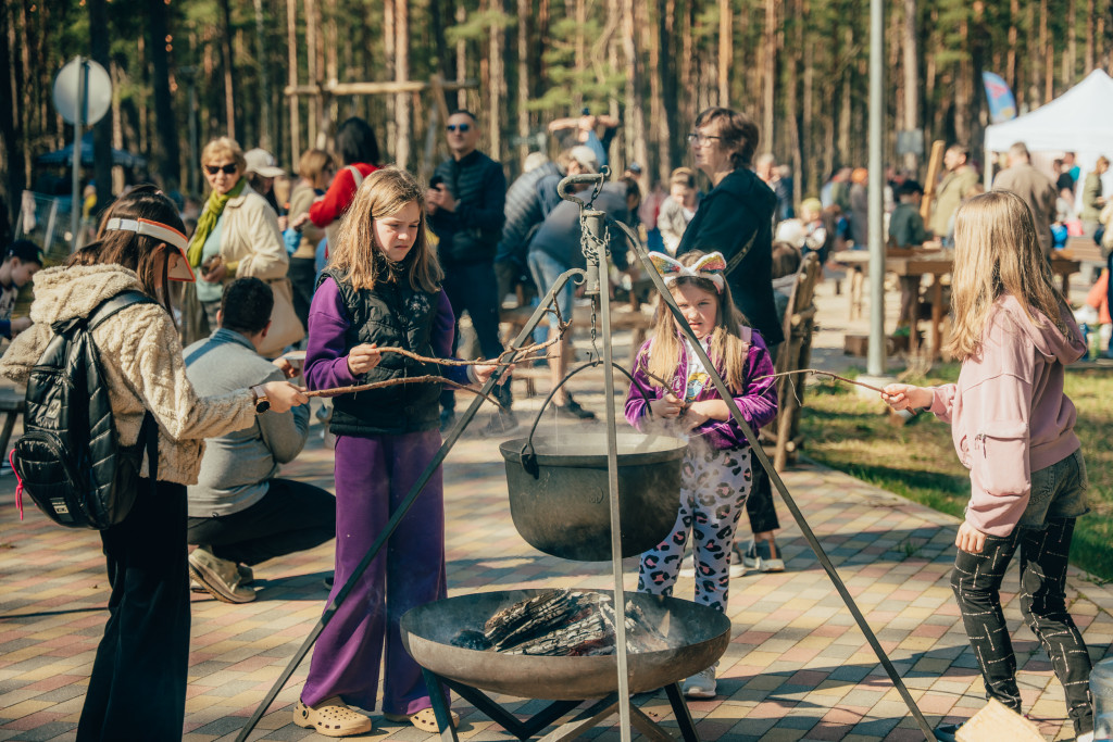Bērni Lieldienu pasākumā Saulkrastos cep desiņas pie ugunskura
