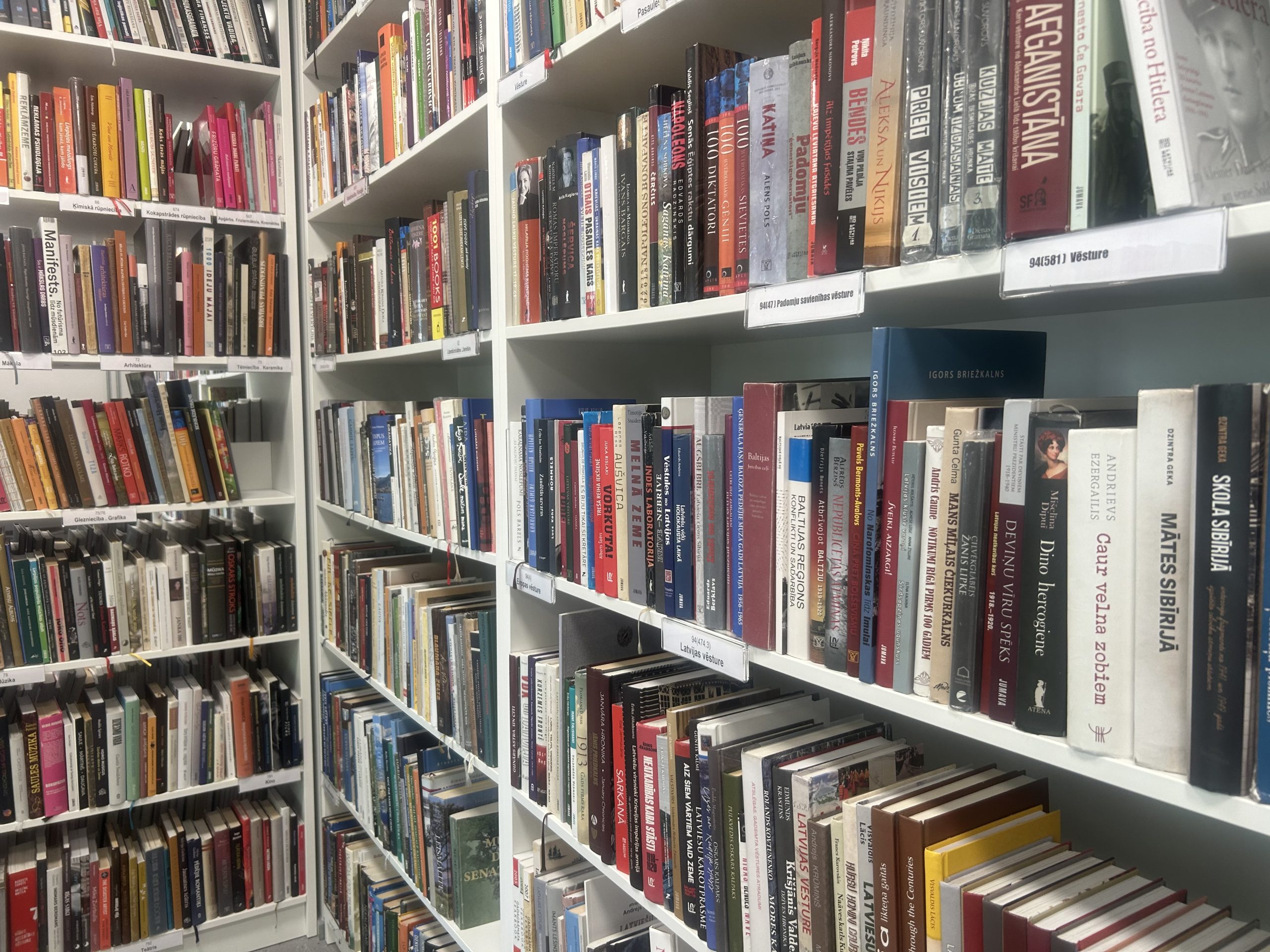 Grāmatplaukti ar vēstures un Latvijas vēstures grāmatām bibliotēkā