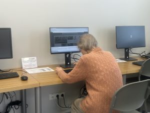 Cilvēks strādā pie datora bibliotēkas datorlasītavā