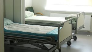 Slimnīcas palāta ar tukšu pacienta gultu