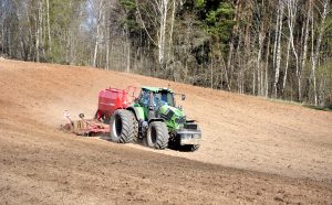 Traktors apstrādā lauku pavasarī Sventes pagastā