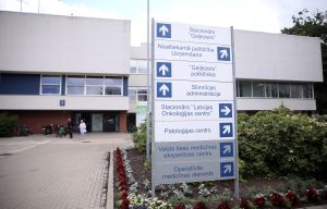 Gaiļezera slimnīcas ēka ar virzienu norādes stendu pie ieejas